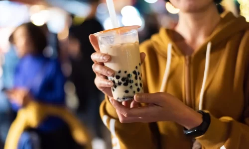 Asian woman holding the famous bubble milk tea at night marketplace